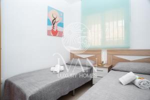 ein Schlafzimmer mit zwei Betten und einem Schreibtisch und einem Spiegel in der Unterkunft Casa Alegría Ivan Luxury Homes 10ªPlta Sur 1ªLinea in Oropesa del Mar