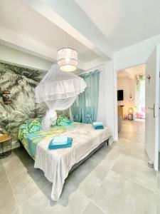 a bedroom with a bed with a canopy at Lodge douceur tropicale Sainte-Luce vue mer in Sainte-Luce +13 photos