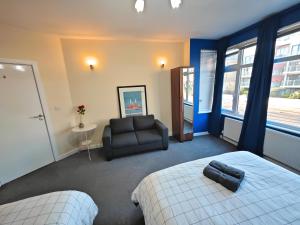 a bedroom with a bed and a chair and a window at Bright and Spacious 2-Bedroom Flat Near Emirates Stadium in London