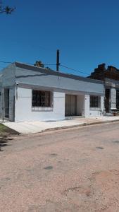 an old white building with barred windows on a street at Amplia en centro de San Gregorio in San Gregorio de Polanco