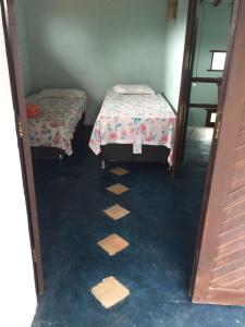 twee bedden in een kamer met tegelvloer bij Casa Laranja in Arraial d'Ajuda