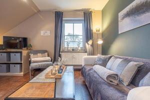 a living room with a couch and a table at fewo1846 Strandresidenz Wassersleben - Strandkoje - komfortables Studioapartment mit Meerblick am Strand in Harrislee +10 photos