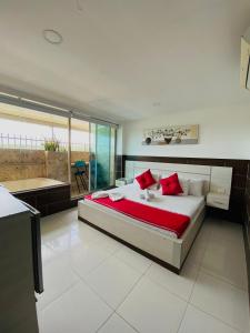 a large bedroom with a large bed with red pillows at Hotel Suite Royal in Melgar +37 photos