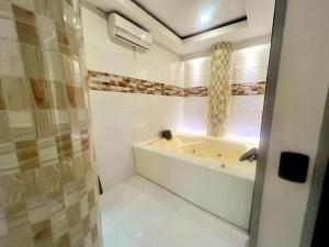 a bathroom with a tub and a shower with a window at Hotel Suite Royal in Melgar +52 photos