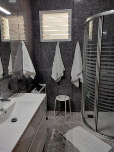 a bathroom with a shower and a sink and a stool at Casa Esperanza in Arinaga +18 photos