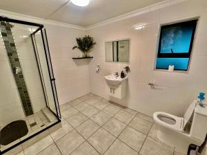 a bathroom with a shower and a toilet and a sink at The Legacy BnB in East London +20 photos