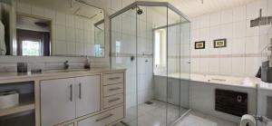 a bathroom with a shower and a sink and a tub at Pousada Casa Campeche - Floripa in Florianópolis +66 photos