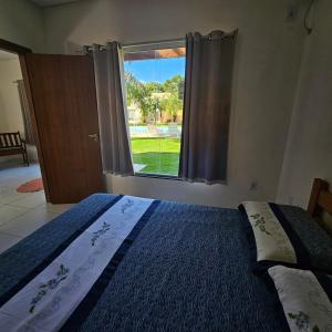 a bedroom with a large bed with a window at Vila Axé Flat 05 Riviera in Prado +23 photos
