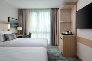 a hotel room with two beds and a television at Courtyard by Marriott Chisinau in Chişinău +25 photos