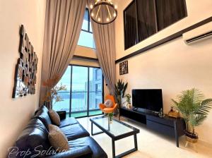 - un salon avec un canapé en cuir noir et une télévision dans l'établissement Loft Suite Seaview 2BR JB CIQ 7Pax, à Johor Bahru