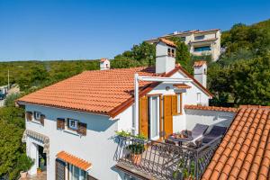 una casa blanca con un techo naranja en Korina, en Kostrena