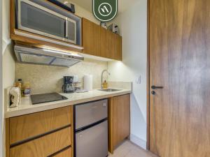 a small kitchen with a sink and a microwave at Luxury Condo with Canal View - Near Beach in Nuevo Vallarta 