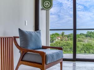a chair with a pillow in front of a window at Luxury Condo with Canal View - Near Beach in Nuevo Vallarta 