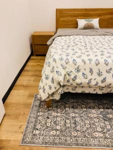 a bed with a comforter and a rug in a bedroom at Oceana Residence 2 in Mont Choisy
