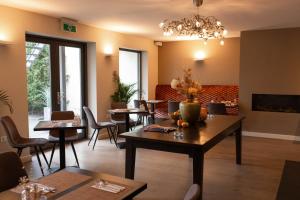 a dining room with tables and chairs and a chandelier at Hof van Slenaken - Hotel & Apartments in Slenaken