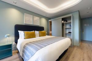 a bedroom with a large bed with yellow pillows at Quarters 405 in Cape Town