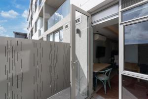 an open glass door to a balcony with a table at Quarters 405 in Cape Town