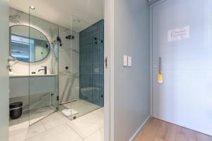 a bathroom with a shower and a glass door at Quarters 405 in Cape Town +6 photos