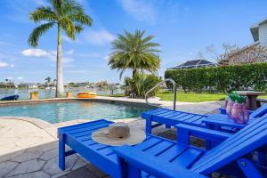 Una mesa de picnic azul con un sombrero junto a una piscina. en Cape Lake House Lake Front, en Lochmoor Waterway Estates