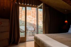 a bedroom with a bed and a sliding glass door at Casa Baladin camere di Charme in Piozzo