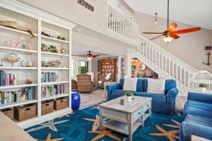 Una sala de estar con sillas azules y una mesa. en Cape Lake House Lake Front, en Lochmoor Waterway Estates