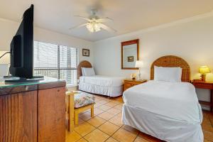 a bedroom with two beds and a flat screen tv at Ocean Vista #1101 in South Padre Island