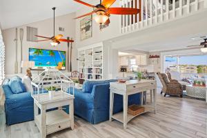 Una sala de estar con un sofá azul y una mesa. en Cape Lake House Lake Front, en Lochmoor Waterway Estates