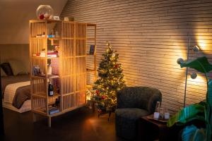 a room with a christmas tree and a book shelf at Studio Kittel Guest Room with Private Bathroom in Bruges