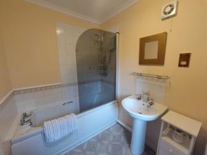 a bathroom with a sink and a tub and a toilet and a sink at Rowan Cottage, NC500 in Greenland
