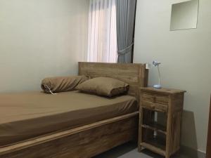 a bedroom with a wooden bed with a night stand at 3 Bedroom Fully Furnished LC Home in Singaraja