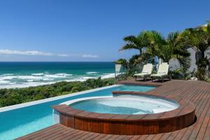 a pool with a hot tub on a deck with the ocean at Heaven's Door in Trafalgar