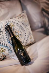 a bottle of champagne sitting on top of a bed at Residenza San Vito in Calamandrana
