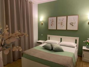 a bedroom with a bed with green walls at Cicero’s - Intero alloggio in Castelbuono