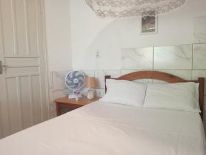 Un dormitorio con una cama blanca con cabecero de madera. en Casa Bacana Boipeba, en Isla de Boipeba