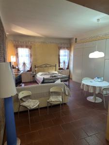 a bedroom with two beds and a table and chairs at La Suite del Doge - Parking in Treviso