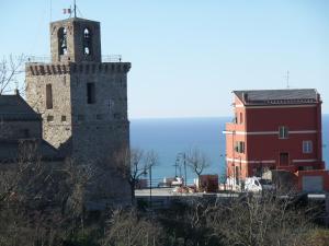 una vecchia torre con una croce in cima a un edificio di Hotel Meri 1956 Locanda e Cucina a Framura