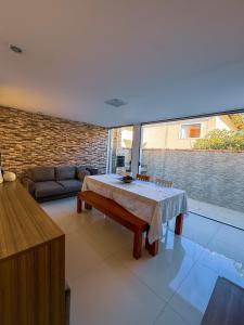 a living room with a table and a couch at 230m da PRAIA, casa com ESPAÇO GOURMET e CHURRASQUEIRA, Portaria 24h, 2 VAGAS de GARAGEM, acomoda até 10 PESSOAS, Próximo a MERCADOS e FARMÁCIA in Salvador