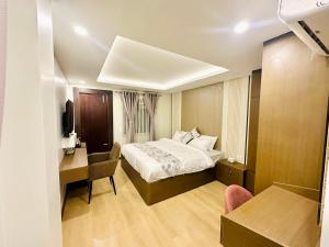 a hotel room with a bed and a desk and a desk at Airport Budget Hotel in Pashupatināth