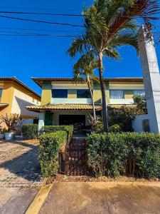 a house with a palm tree in front of it at 230m da PRAIA, casa com ESPAÇO GOURMET e CHURRASQUEIRA, Portaria 24h, 2 VAGAS de GARAGEM, acomoda até 10 PESSOAS, Próximo a MERCADOS e FARMÁCIA in Salvador