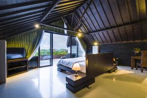 a bedroom with a bed and a large window at 14 Palms in Uluwatu