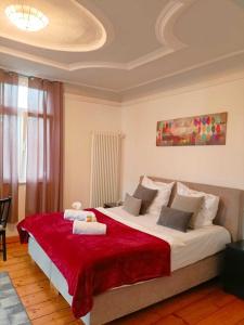 a bedroom with a large bed with a red blanket at Gasthaus zum Halbmond in Speyer