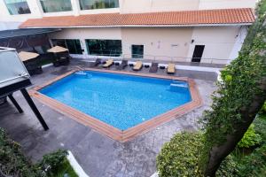 an overhead view of a swimming pool with chairs and a building at Holiday Inn Uruapan by IHG in Uruapan del Progreso