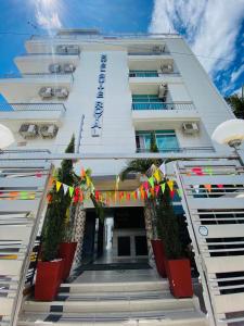 a white building with colorful flags in front of it at Hotel Suite Royal in Melgar