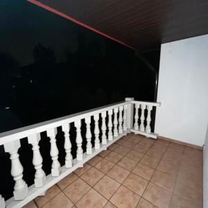 a balcony with a white railing and a wall at Valda House in Rybie