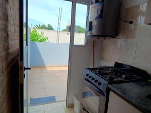 a kitchen with a stove top oven next to a window at Departamento amplio en zona tranquila cercana al centro de Ezeiza in Ezeiza