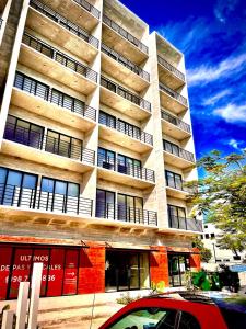 カンクンにあるCondo in the perfect spot at downtown Cancunの前に車が駐車されている高い建物