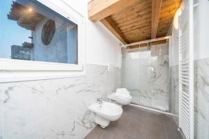 ウーディネにあるElegance in Udine! Matteotti Apartmentsのトイレと洗面台を備えた白いバスルーム +8枚の写真