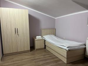 a small bedroom with a bed and a cabinet at The View Apartments in Yerevan