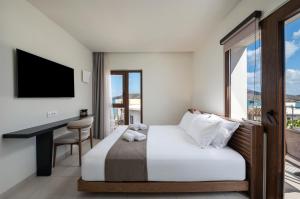 une chambre d'hôtel avec un lit, un bureau et une fenêtre dans l'établissement Elounda Stories Boutique Hotel, à Elounda