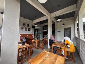 Due donne sedute ai tavoli in un ristorante di The Cluster Harris a Cimahi